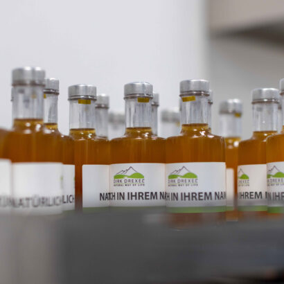 Reihe von abgefüllten und etikettierten Flaschen mit Naturprodukten - Privat Label Dirk Drexel - In Ihrem Namen