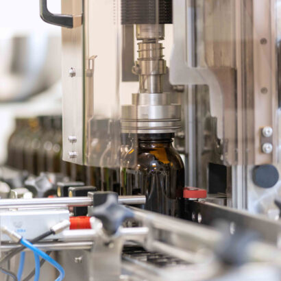 Verschließen von braunen Glasflaschen in einer automatisierten Produktionslinie